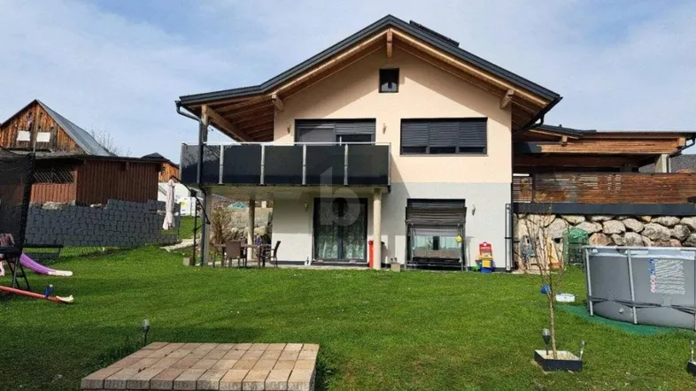 Modernes Einfamilienhaus mit großem Garten, Balkon und Bergblick in gepflegtem Zustand.