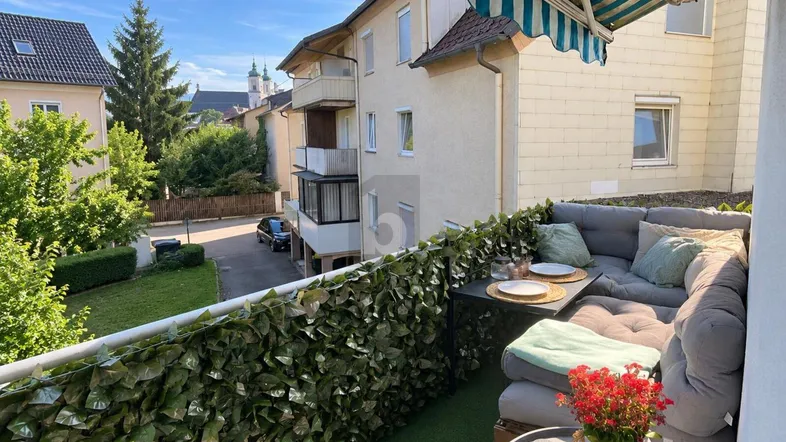 Gemütlicher Balkon mit bequemen Sitzmöbeln und Blick auf die Umgebung.