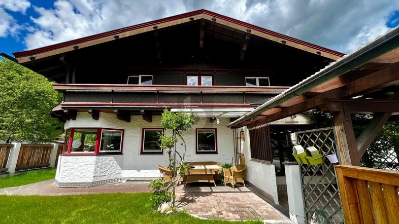Traditionelles Haus im alpinen Stil mit gepflegtem Gartenbereich und kleiner Terrasse für entspannte Stunden im Freien.