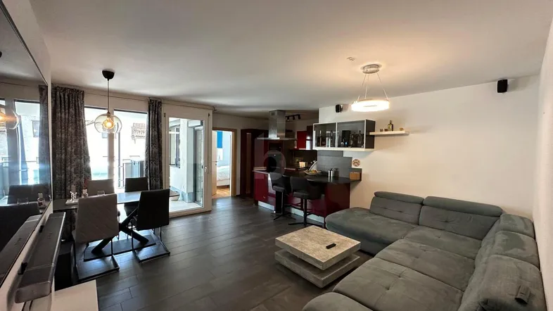 Helles, offenes Wohnzimmer mit integriertem Essbereich und moderner Küche, ideal für geselliges Beisammensein.