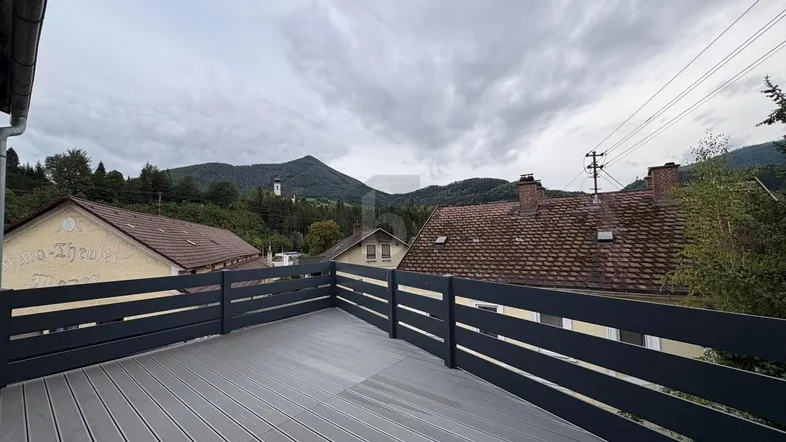 Geräumige Terrasse mit modernem Geländer und weitem Blick auf die umliegende Berglandschaft.