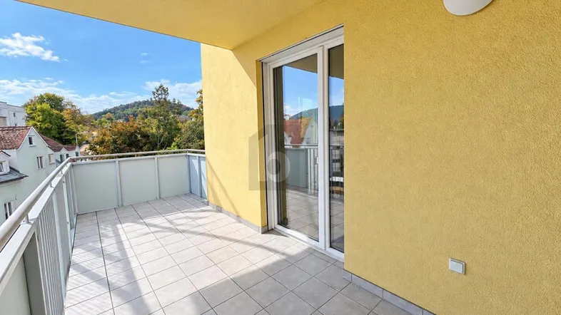 Geräumiger Balkon mit Fliesenboden und schöner Aussicht ins Grüne.