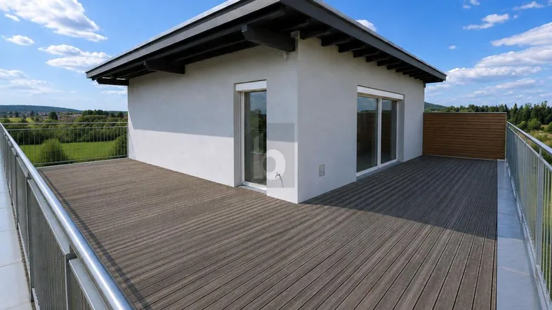 Große Dachterrasse mit Holzbelag und weitem Blick ins Grüne unter blauem Himmel.