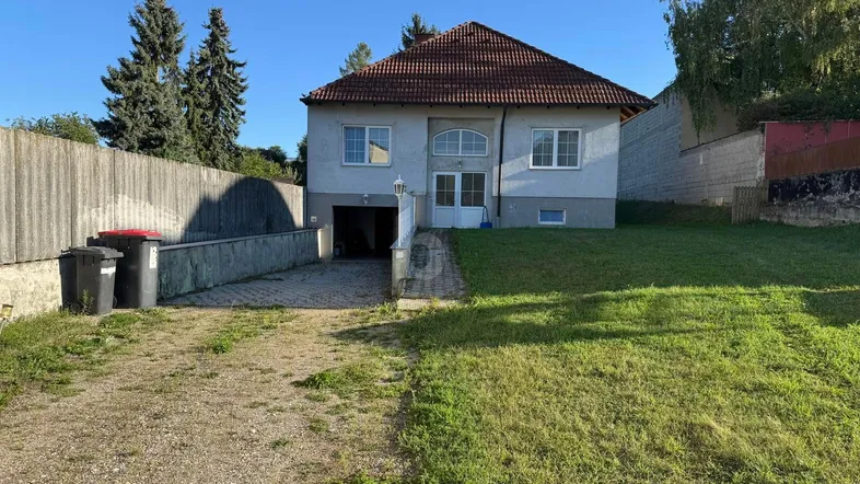 Einfamilienhaus mit Satteldach, Garage und großem Vorgarten in ländlicher Umgebung.