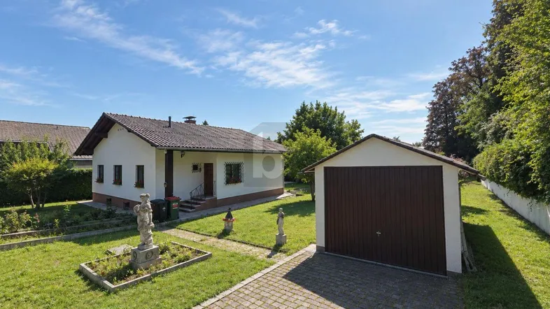 Außenansicht des Hauses mit separater Garage, gepflasterter Einfahrt und gepflegtem Vorgarten.
