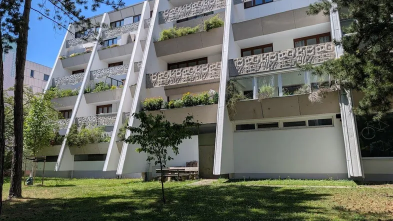 Modernes Terrassenhaus mit begrünten Balkonen und markanter Architektur.