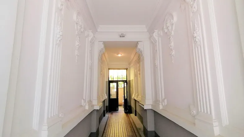 Historischer Flur mit aufwendigen Stuckverzierungen an Wänden und Decke, typisch für Altbauten.