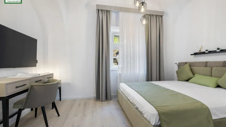 Helles Schlafzimmer mit gewölbter Decke, modernem Bett und Schreibtischbereich.
