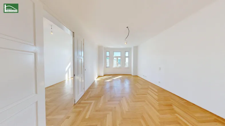Helles, leeres Zimmer mit Fischgrätparkett und Erkerfenstern, ideal für Wohn- oder Schlafbereich.