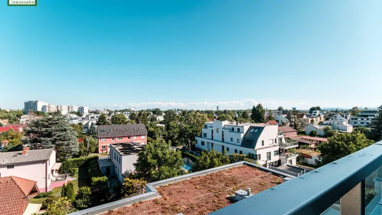 Weitläufiger Blick über die Stadt und umliegende Wohngebäude von einer Dachterrasse.