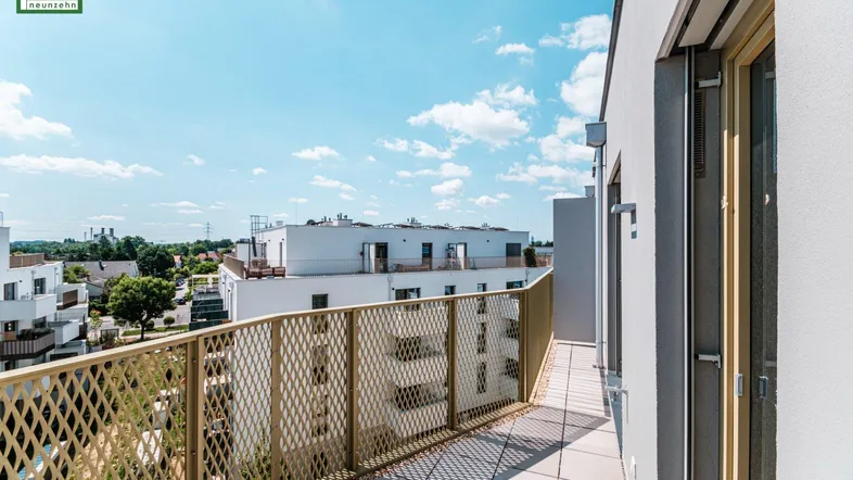 Geräumiger Balkon mit Fliesenboden und Blick auf die umliegenden modernen Gebäude.
