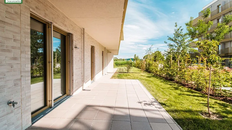 Große gepflasterte Terrasse mit direktem Zugang zum Garten und Blick auf die Umgebung.