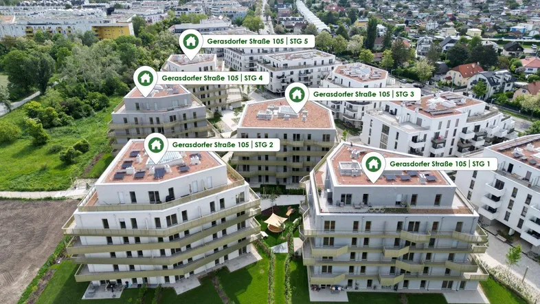 Luftaufnahme einer modernen Wohnanlage mit mehreren Gebäuden und grünen Außenbereichen.
