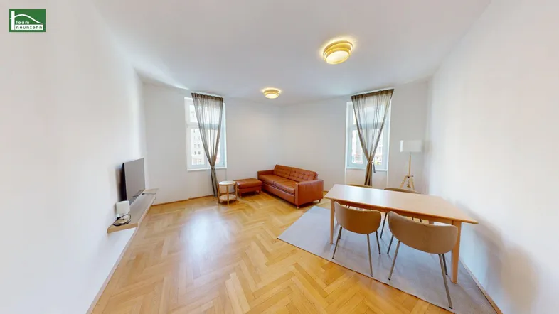 Helles Wohn- und Esszimmer mit Fischgrätparkett, bequemer Ledercouch und Esstisch für gesellige Stunden.