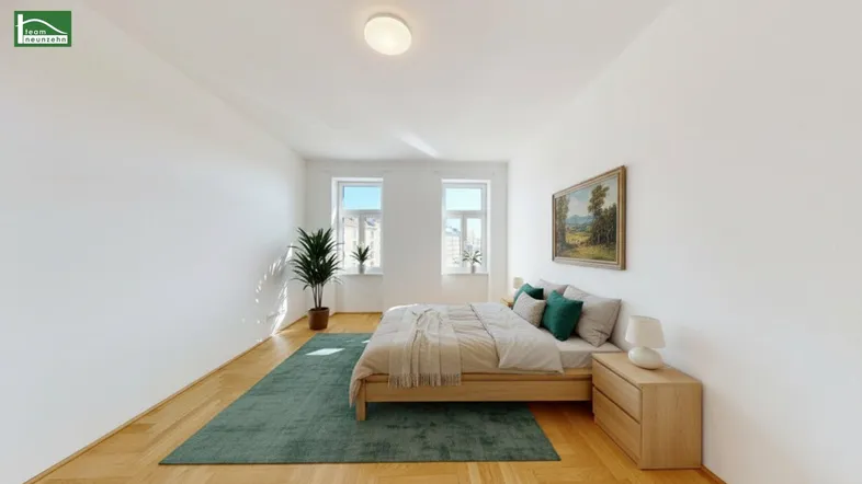 Helles Schlafzimmer mit Parkettboden, einem großen Bett und einem grünen Teppich.