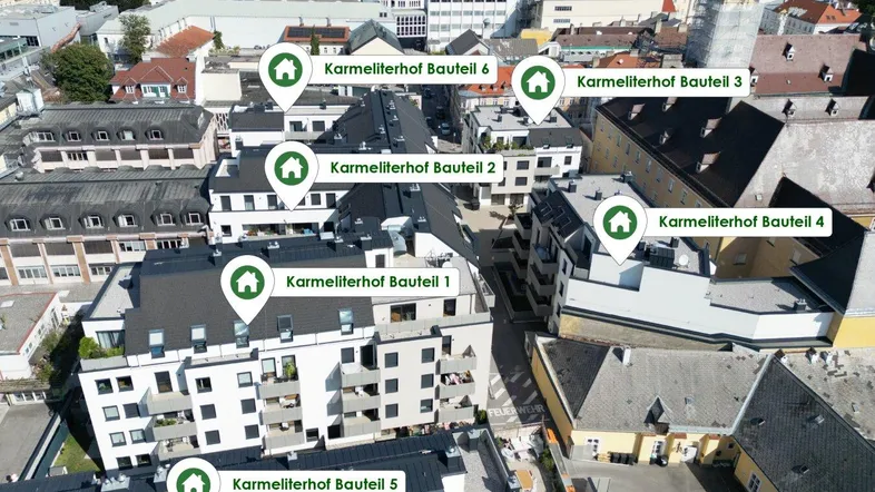 Luftaufnahme des Karmeliterhof-Komplexes mit mehreren Gebäudeteilen in städtischer Umgebung.