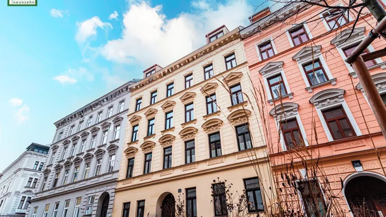 Historische Gebäudezeile mit klassischer Architektur und blauer Himmel über der Stadt.
