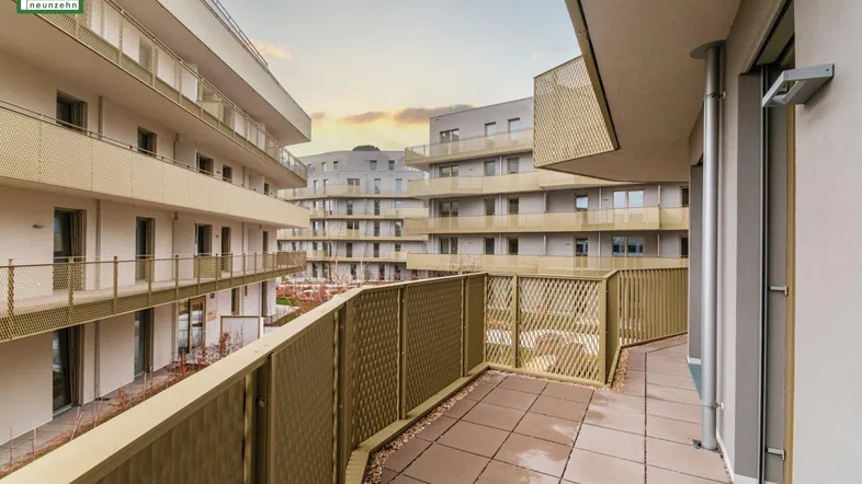 Geräumiger Balkon mit Fliesenboden und Blick auf die umliegenden Gebäude.