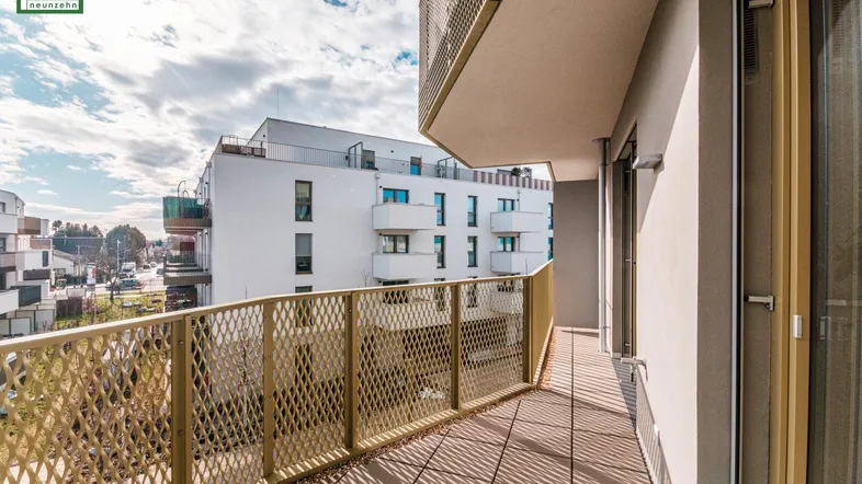 Langer Balkon mit modernem Metallgeländer und Ausblick auf die umliegenden Gebäude.