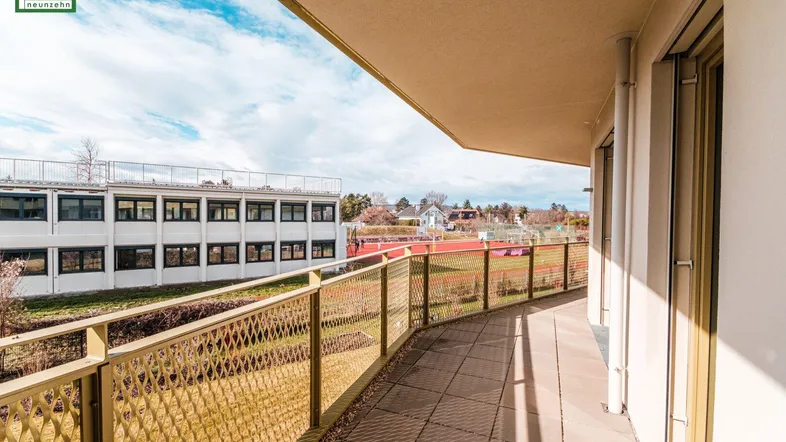 Sonniger Balkon mit Gittergeländer und weitem Blick ins Grüne und die Landschaft.
