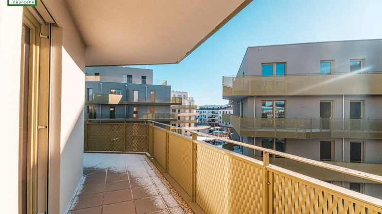 Breiter Balkon mit Fliesenboden und gelbem Metallgeländer, bietet weite Aussicht.