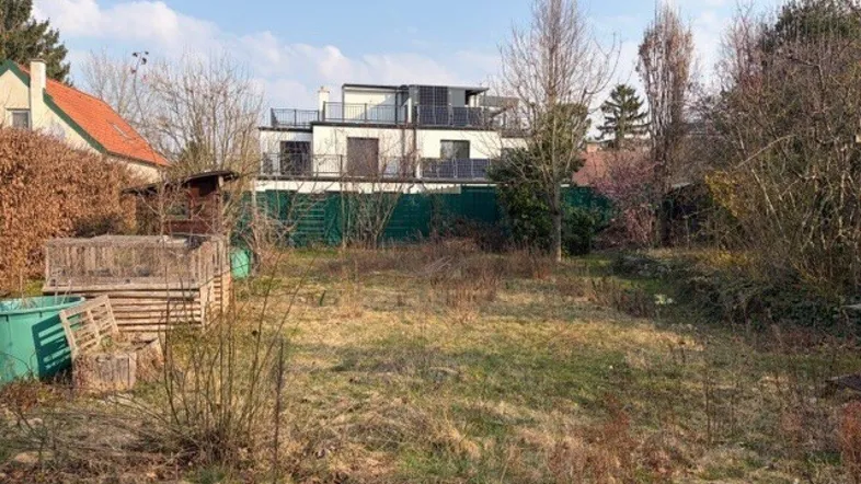 Weitläufiger Garten mit Blick auf ein modernes Gebäude mit Flachdach und Solaranlage.