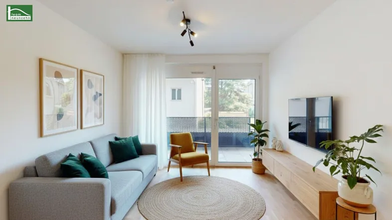 Helles Wohnzimmer mit modernem Sofa, Holzboden und Zugang zu einem Balkon.