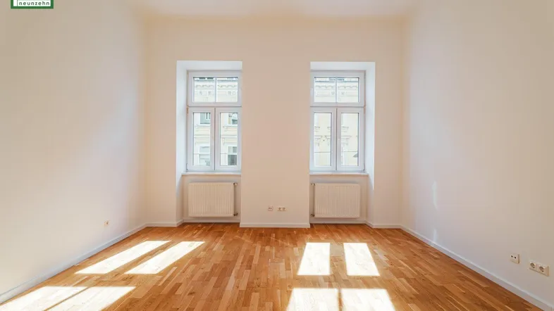 Helles Zimmer mit zwei Fenstern, Holzboden und viel natürlichem Licht, bereit zur Einrichtung.