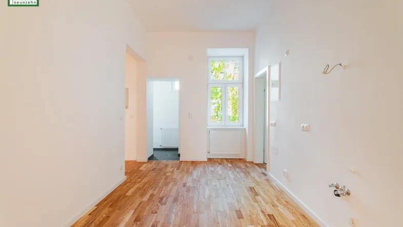 Heller Raum mit Parkettboden, weißen Wänden und einem Fenster, bereit für die individuelle Gestaltung.