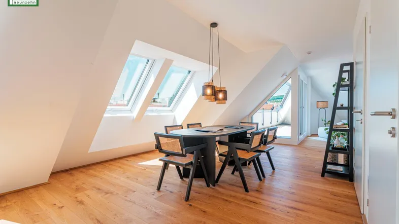 Heller Essbereich im Dachgeschoss mit Holzboden, modernem Esstisch und Zugang zur Terrasse.