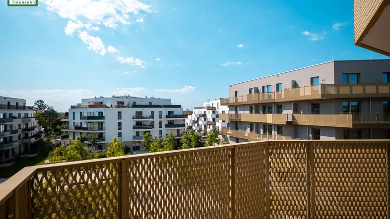 Balkon mit moderner Gitterbrüstung und Blick auf umliegende Wohngebäude.