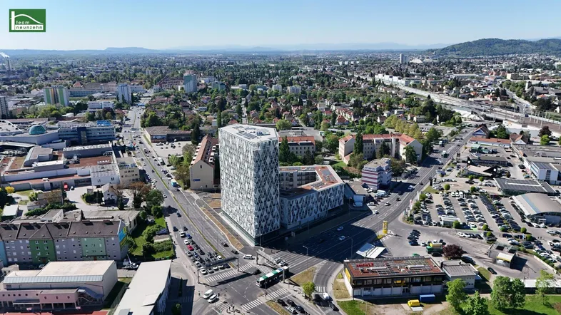 Luftaufnahme eines modernen Gebäudekomplexes in einer städtischen Umgebung mit weitreichendem Blick.