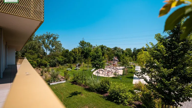 Gemeinschaftlicher Gartenbereich mit Spielplatz und viel Grün für Kinder.