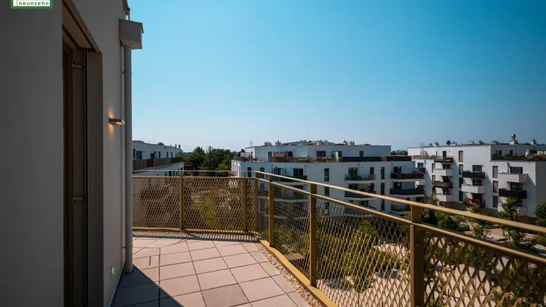 Geräumiger Balkon mit Fliesenboden und Blick auf die umliegenden Gebäude.