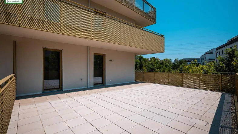 Weitläufige Terrasse mit Fliesen und goldfarbenen Geländern, ideal für Entspannung im Freien.