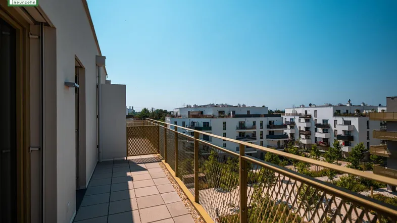 Langer Balkon mit moderner Gitterbrüstung und weitem Blick über die Wohnanlage.
