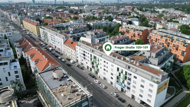 Luftaufnahme einer städtischen Wohngegend mit modernen Gebäuden und einer belebten Straße.