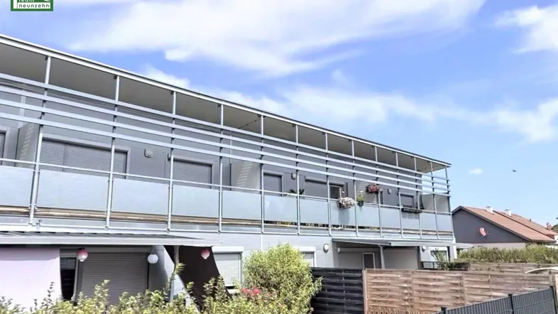 Moderne Wohnanlage mit mehreren Balkonen und einer klaren, funktionalen Architektur unter blauem Himmel.