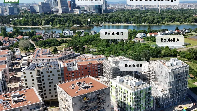 Luftaufnahme eines Neubauprojekts mit mehreren Gebäudeteilen und Blick auf den Donaupark und die Stadt.
