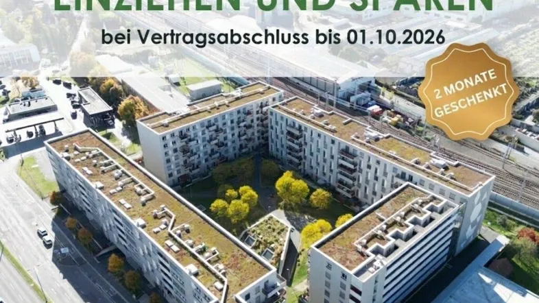 Luftaufnahme moderner Wohngebäude mit begrünten Flachdächern und Balkonen in urbaner Umgebung.