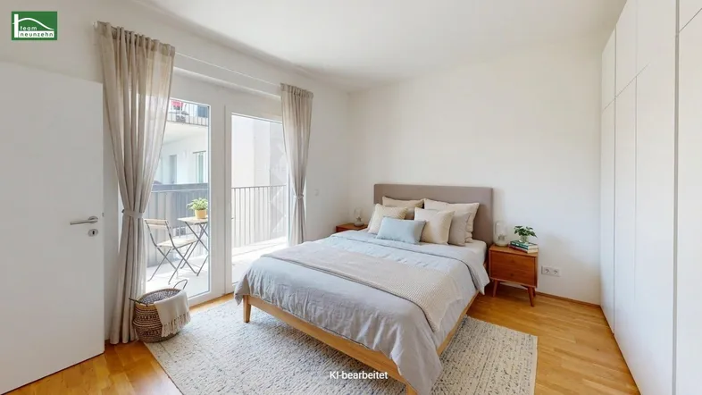 Helles Schlafzimmer mit Holzboden, Zugang zum Balkon und modernem Bett.