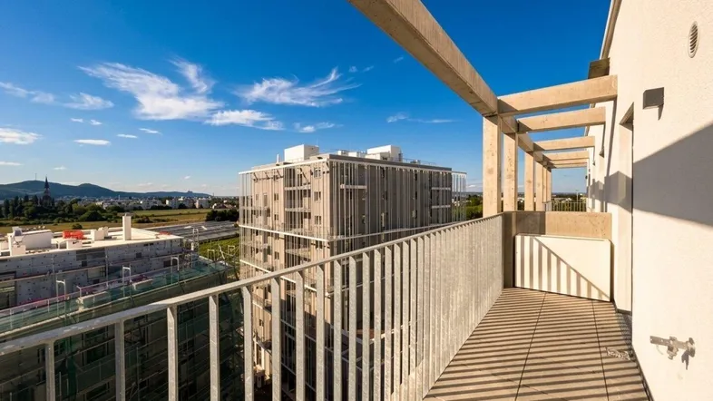 Geräumiger Balkon mit Fliesenboden und weitem Blick über die Stadt und grüne Umgebung.