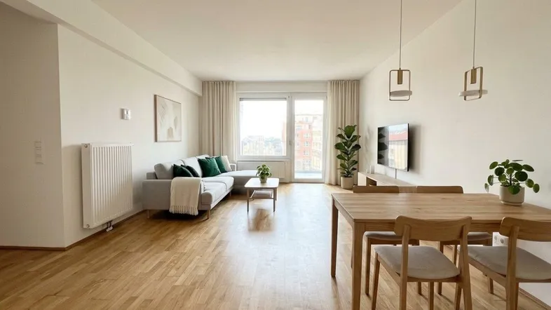 Helles Wohn- und Esszimmer mit Holzboden, modernen Möbeln und Zugang zum Balkon.
