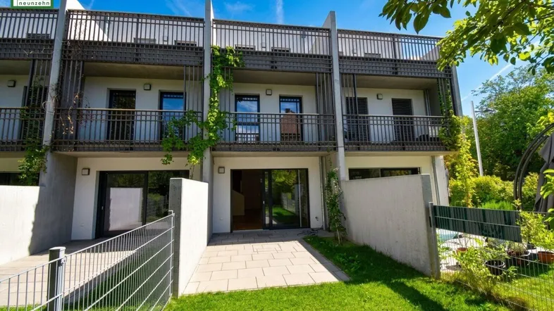 Moderne Reihenhäuser mit privaten Gärten und Balkonen, ideal für Familienleben im Grünen.