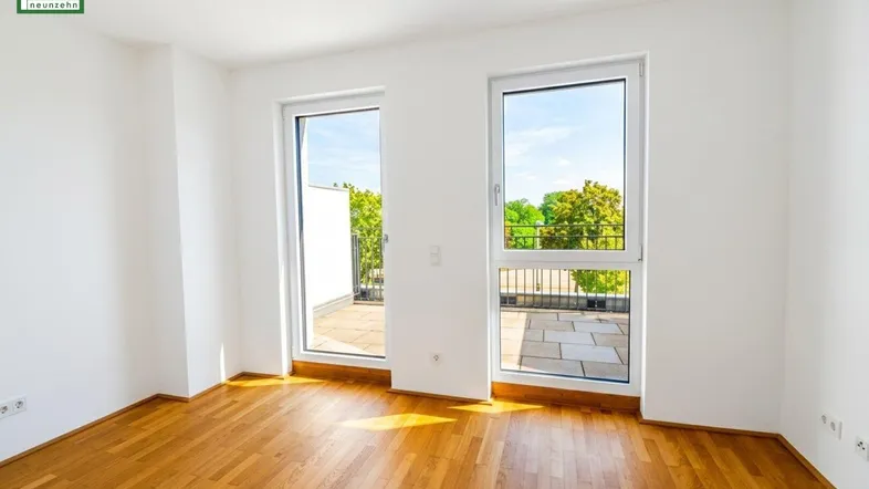 Helles Zimmer mit Holzboden und Zugang zu einer großzügigen Terrasse, ideal als Schlafzimmer oder Büro.