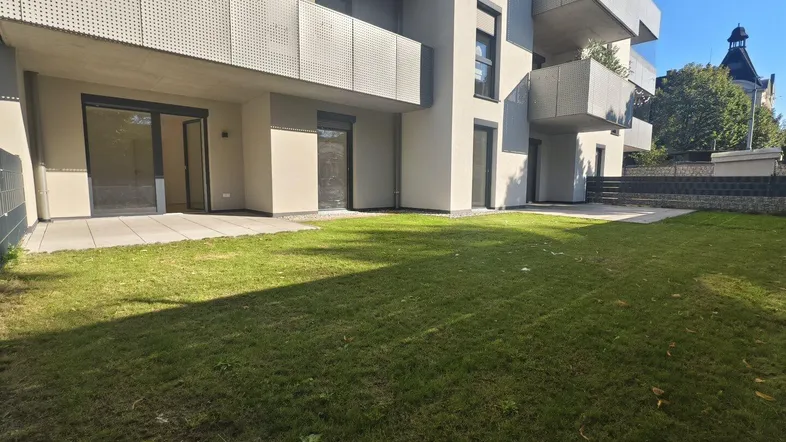 Moderner Neubau mit großzügiger Terrasse und privatem Gartenbereich im Erdgeschoss.