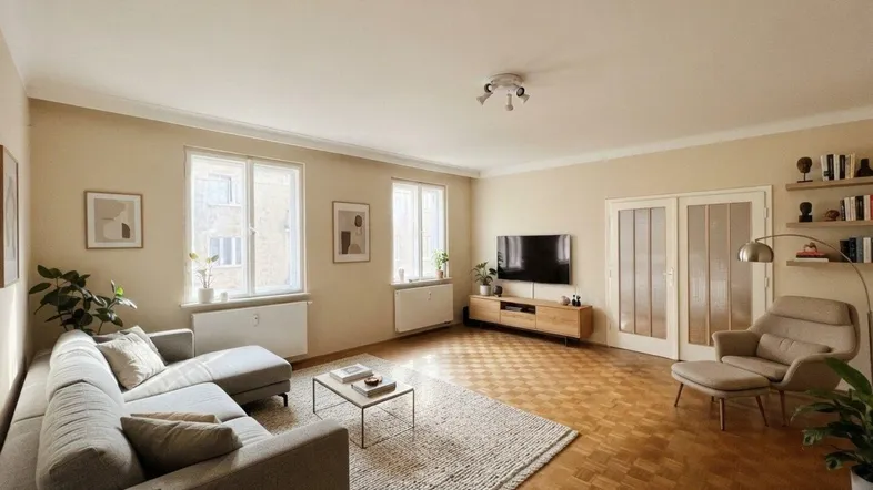 Helles, modern eingerichtetes Wohnzimmer mit Parkettboden und gemütlicher Sitzecke.