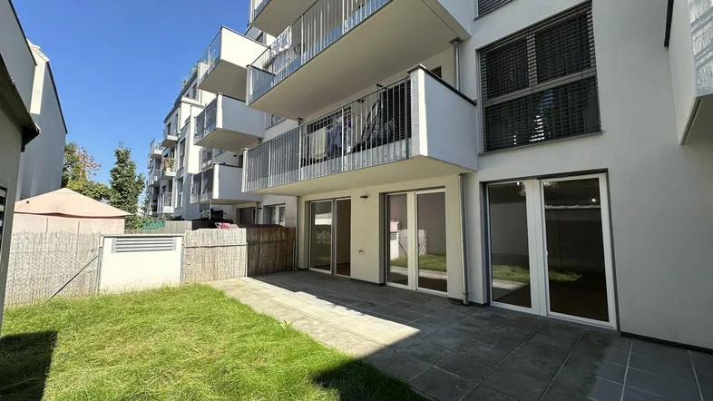 Moderne Wohnanlage mit großzügiger Terrasse und privatem Gartenbereich im Erdgeschoss.