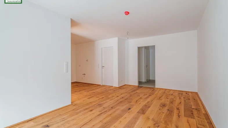 Heller, leerer Raum mit Holzboden und weißen Wänden, bereit für die individuelle Gestaltung.