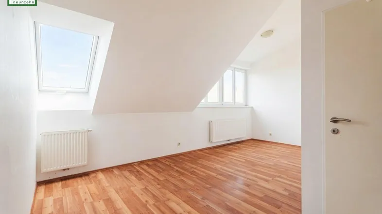 Helles Zimmer im Dachgeschoss mit Holzboden und Dachfenster, ideal als Schlaf- oder Arbeitsbereich.